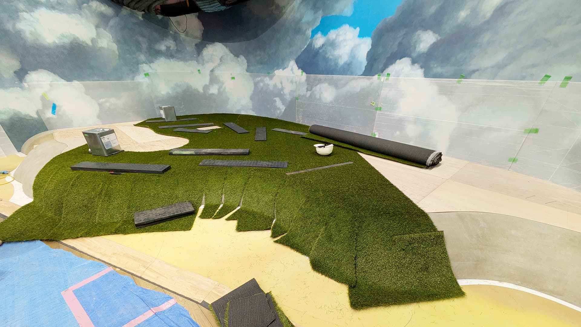 丘の形状に合わせて人工芝を調整している現場の様子