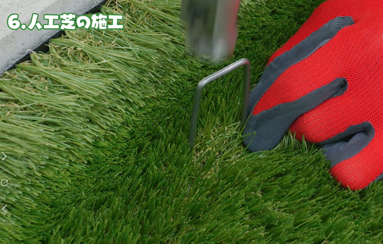 人工芝にピンを打ち込む様子