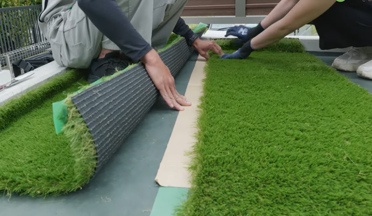 人工芝の下にジョイントテープを敷いている様子